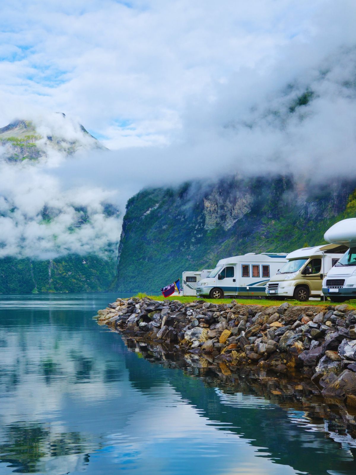 Wohnmobile an einem Fjord zwischen Bergen und Wolken